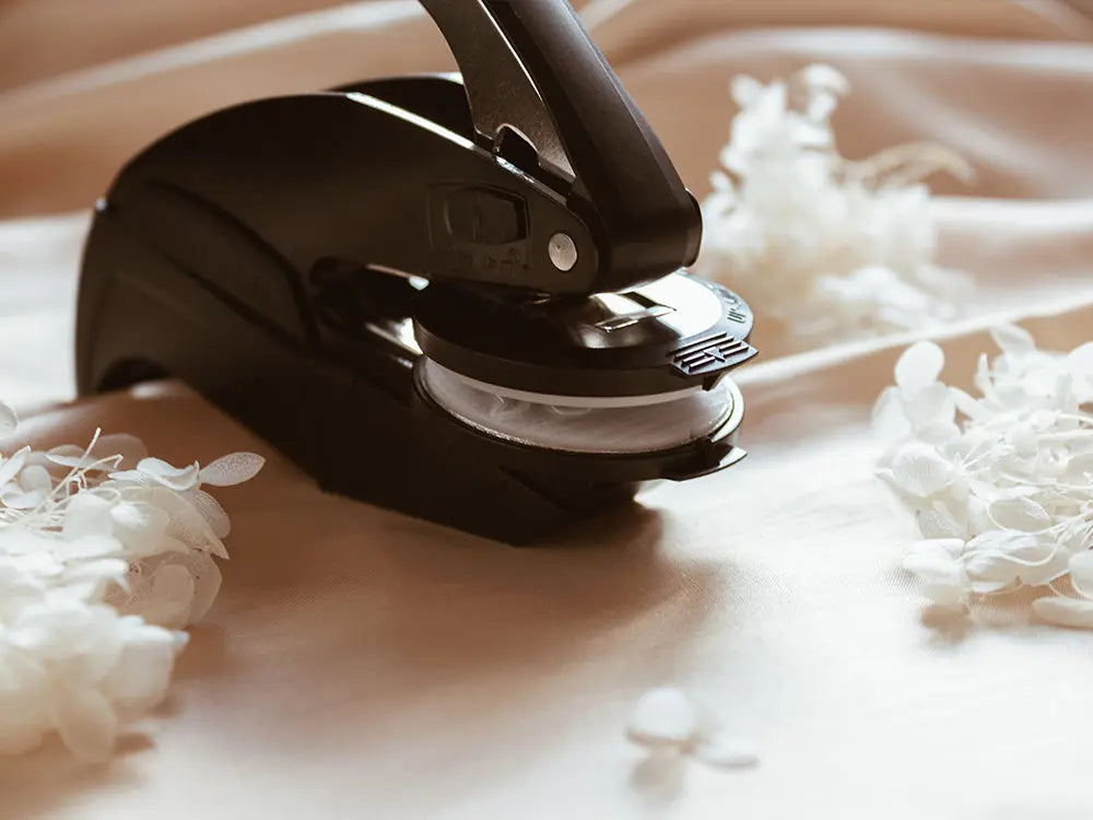 Sello en golpe en seco para crear un relieve elegante y sin tinta, ideal para personalizar invitaciones, certificados y documentos de lujo con un toque sofisticado.