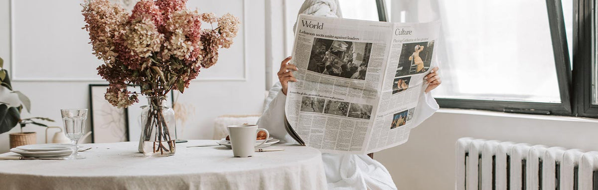 chica sentada leyendo el periódico