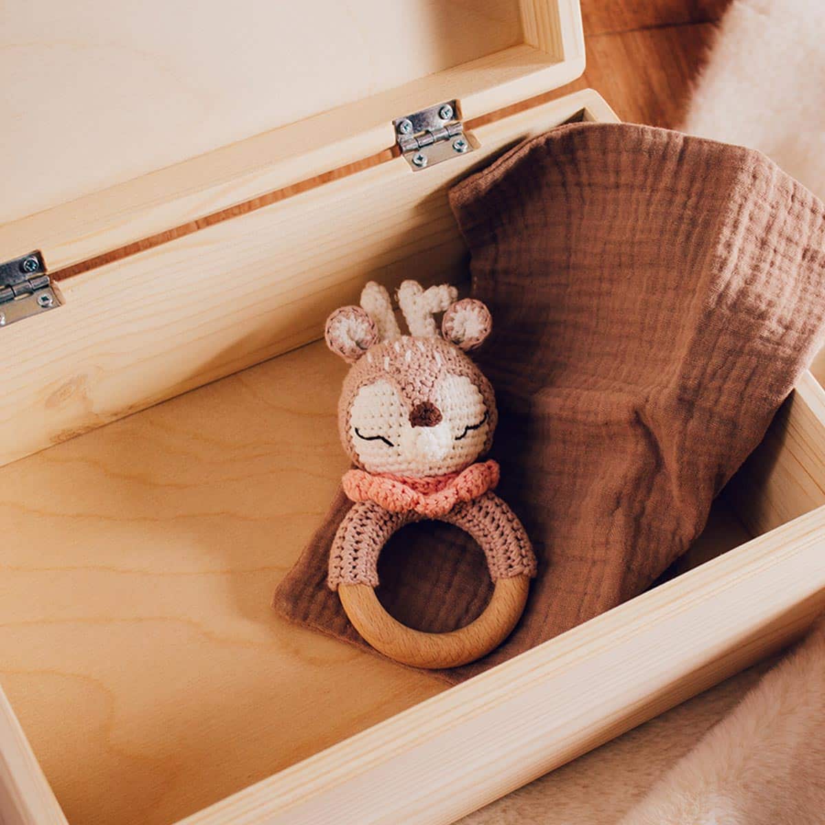 Interior de caja de nacimiento bebé personalizada con sonajero de crochet y toalla de bebé
