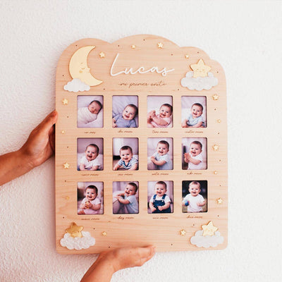Marco de fotos de primer año para bebé en madera con diseño de luna y estrellas sostenido con las manos