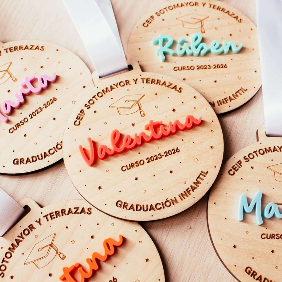 Medalla de graduación de madera varios nombres plano cerca