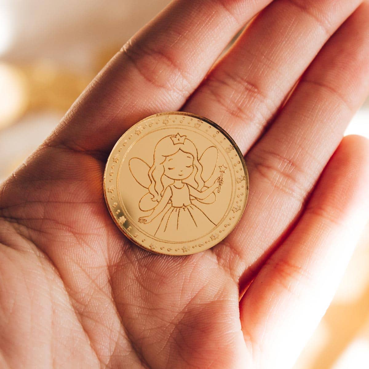 Monedas Hada de los Dientes plano detalle en la mano
