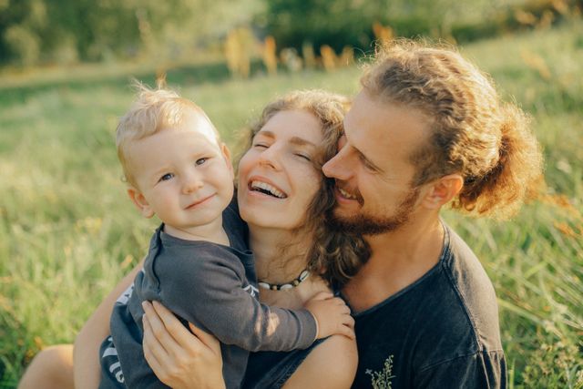 Padres con su hijo riendo en el campo